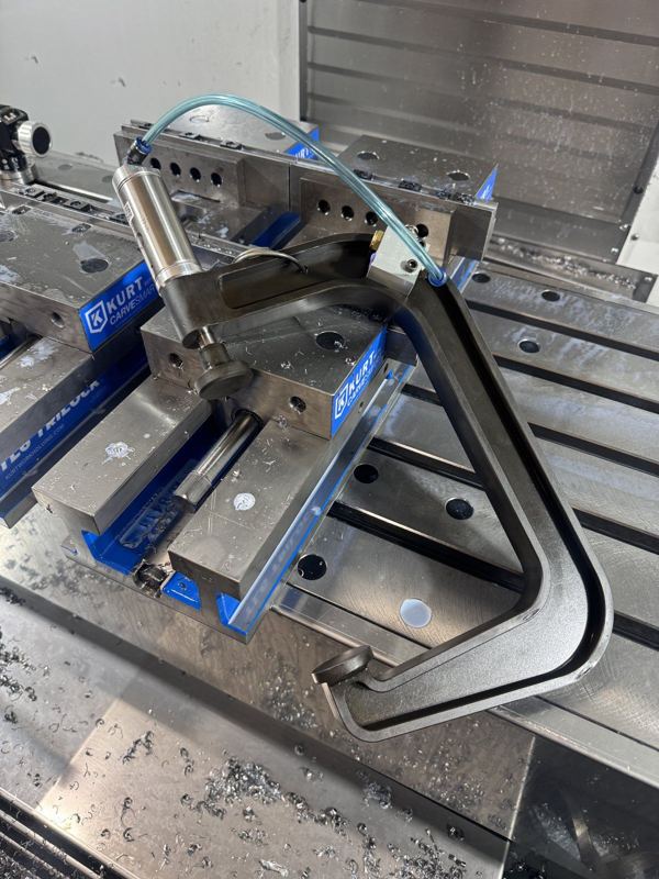 Custom pneumatic clamp fixture mounted on Kurt vises on the mill table