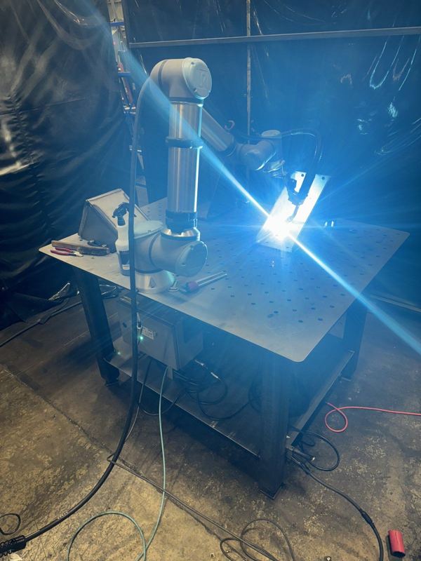 Universal Robots cobot welding on a fixture table in our shop