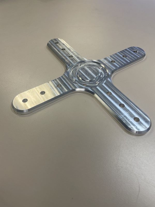 Machined aluminum cross plate with a bored center and bolt pattern
